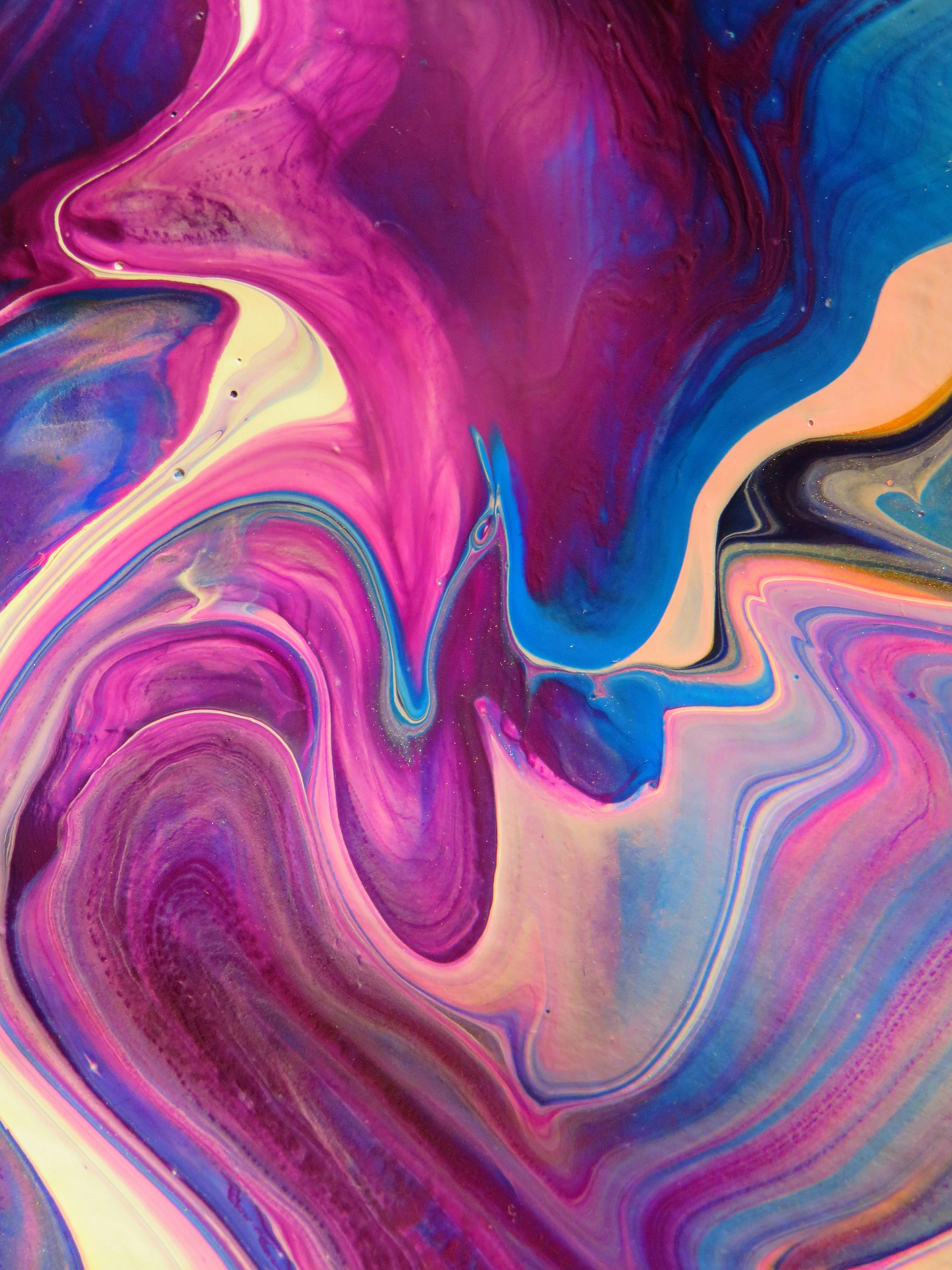 Abstract paint swirls in magenta, blue, white